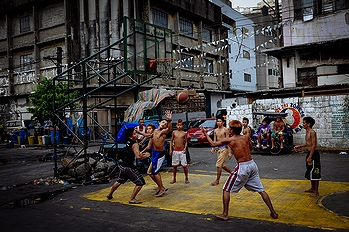 フィリピンの首都マニラの街頭で「フィリピンの人気スポーツ」の一例として挙がったバスケットボールに興じる地元の青少年たち(2014年)の画像