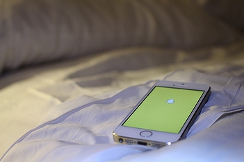 アップル社製のスマートフォン「iPhone」とSNSアプリ「スナップチャット」(2014年・米国ラスベガス)の画像