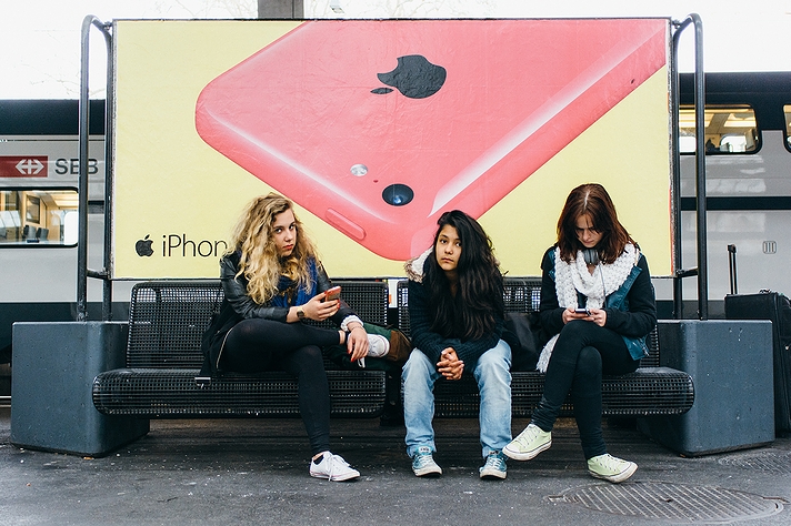 駅構内の「iPhone」の看板広告と少女たち(2014年・スイス)の画像